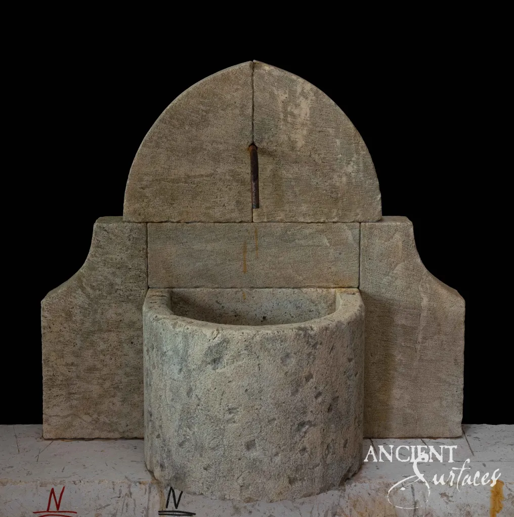 Reclaimed limestone wall fountain with a domed arch backplate and a half-round drum basin