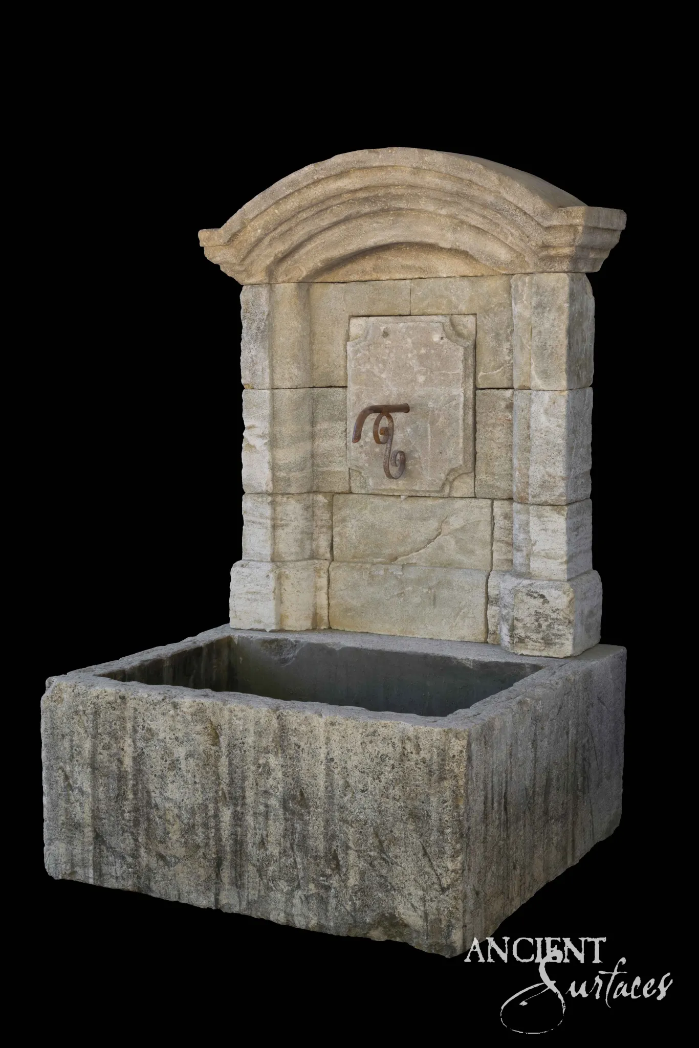 Reclaimed limestone wall fountain with an arched pediment, carved cartouche panel and iron scroll spout over a deep trough